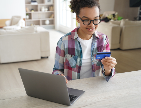 teen girl on laptop using credit card