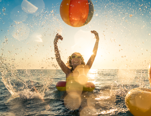 woman playing in ocean with beach ball