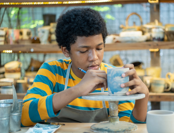 teen boy making pottery