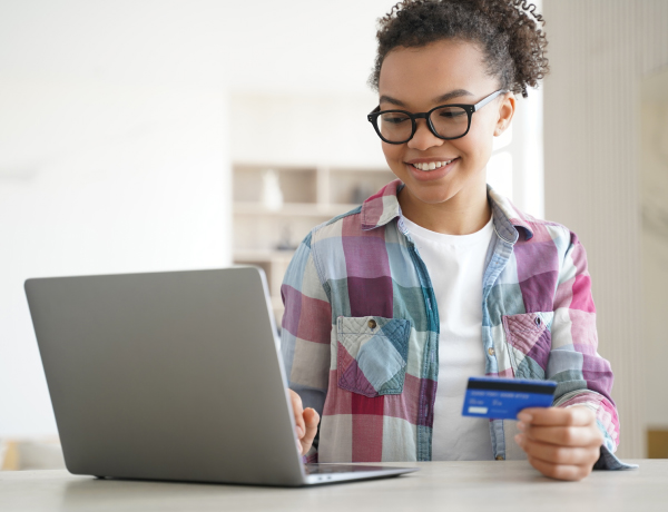 teen girl shopping with credit card on laptop