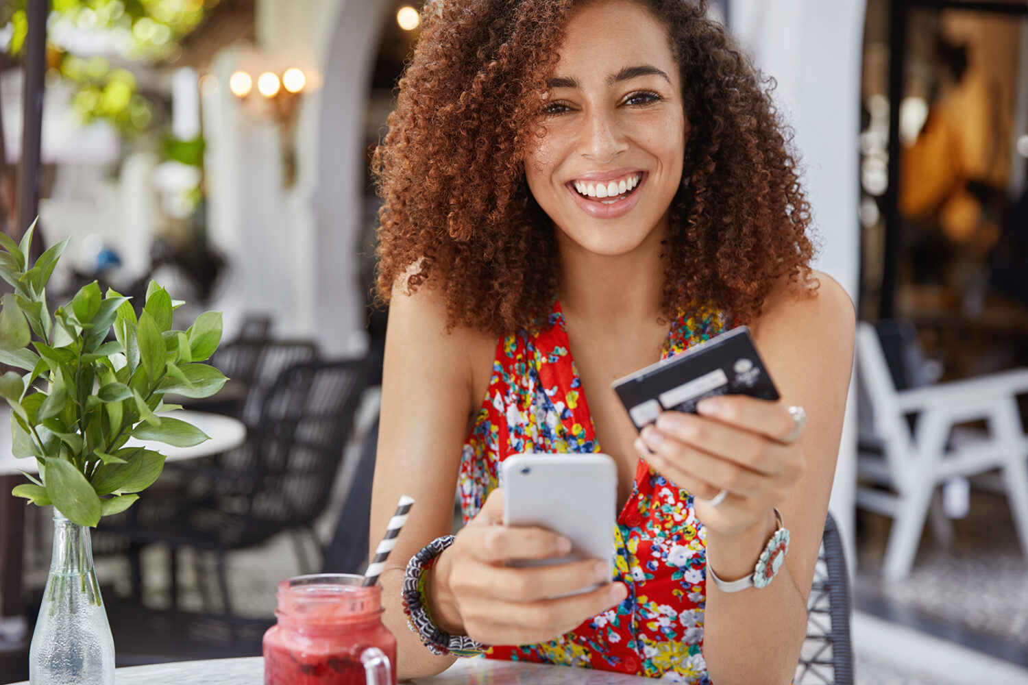 happy young female using credit card on cellphone
