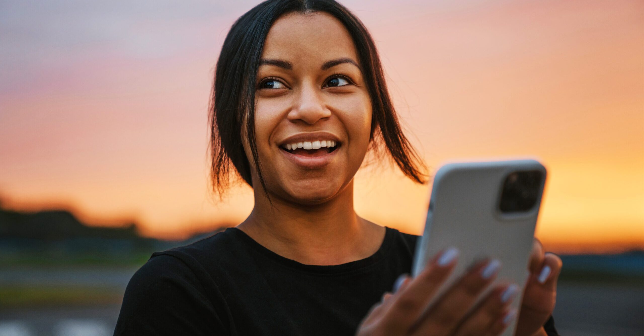 woman smiling and holder her phone