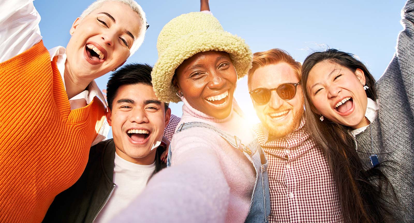 Smiling selfie of a happy group of multicultural friends looking at the camera. Portrait of cheerful multi-ethnic young people of diverse races having fun together. Community and friendship concept